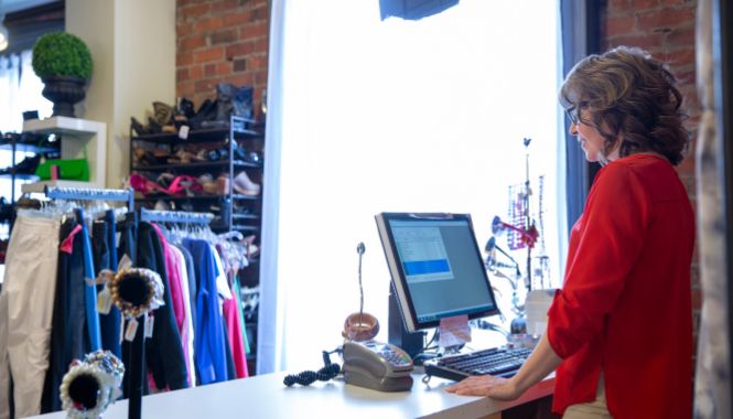 Female shop owner organizing products in her store, representing small business operations covered by commercial insurance